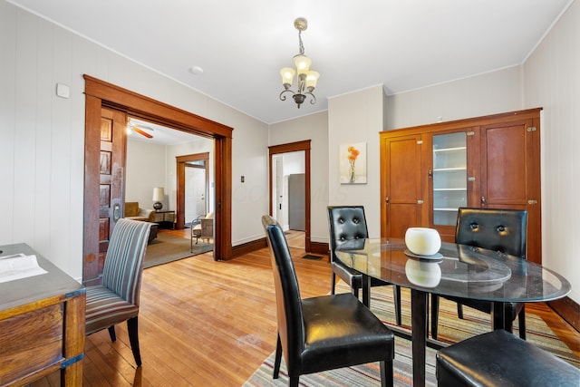 dining space featuring light wood-type flooring and a notable chandelier