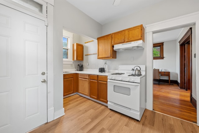 kitchen with white gas stove and light wood-type flooring