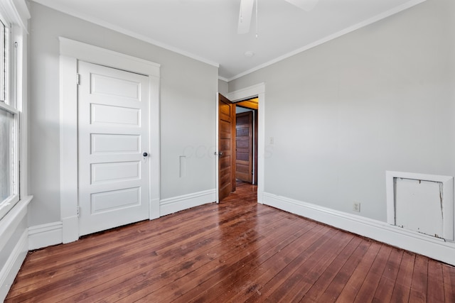 unfurnished bedroom with a closet, crown molding, dark hardwood / wood-style floors, and ceiling fan