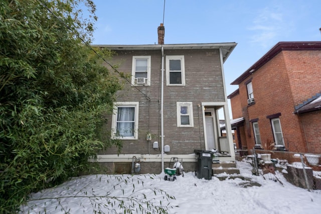 snow covered back of property featuring cooling unit