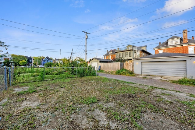view of yard with fence, an outbuilding, and a garage