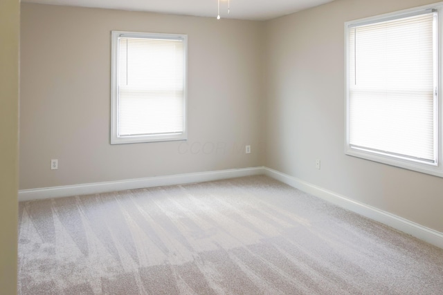 unfurnished room featuring carpet flooring and baseboards