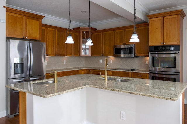 kitchen featuring brown cabinets, a center island with sink, appliances with stainless steel finishes, and a sink