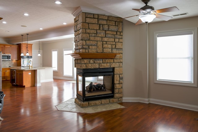 living room with visible vents, wine cooler, a fireplace, baseboards, and dark wood-style flooring