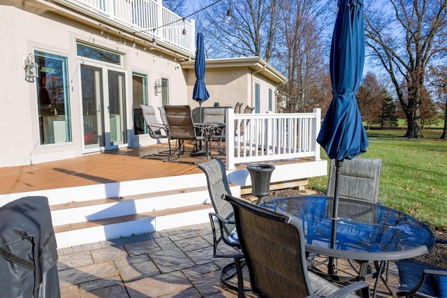 view of patio with outdoor dining area, a balcony, a wooden deck, and french doors