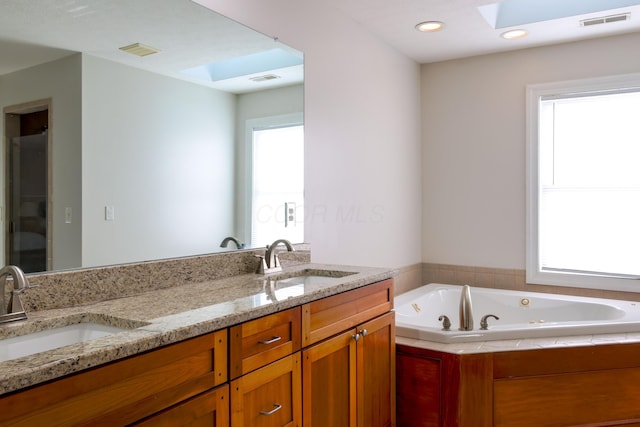 full bath featuring a sink, visible vents, and a skylight