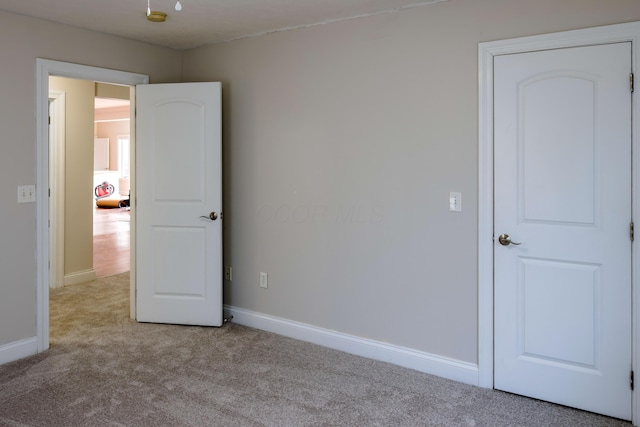 unfurnished bedroom with baseboards and carpet floors