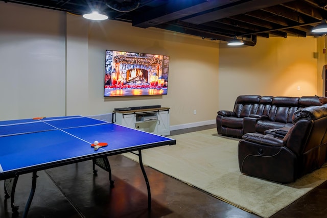 game room featuring baseboards and concrete flooring