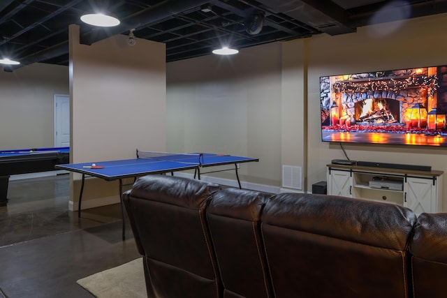 rec room featuring finished concrete flooring, baseboards, and visible vents