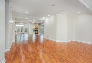 interior space featuring crown molding, baseboards, recessed lighting, a fireplace, and wood finished floors