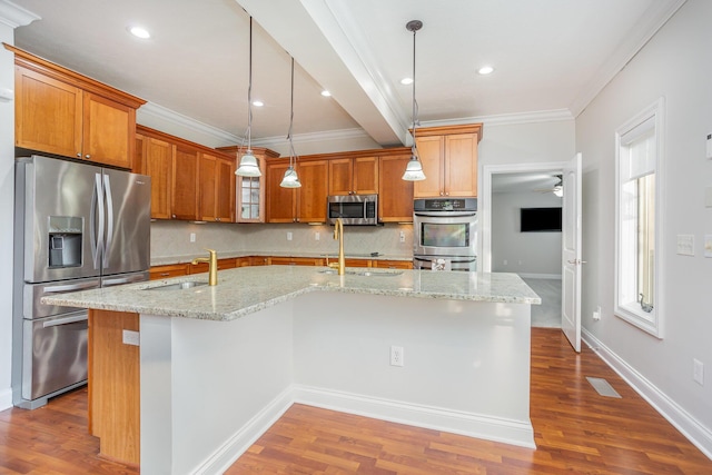 kitchen with a sink, dark wood-type flooring, appliances with stainless steel finishes, and a kitchen island with sink