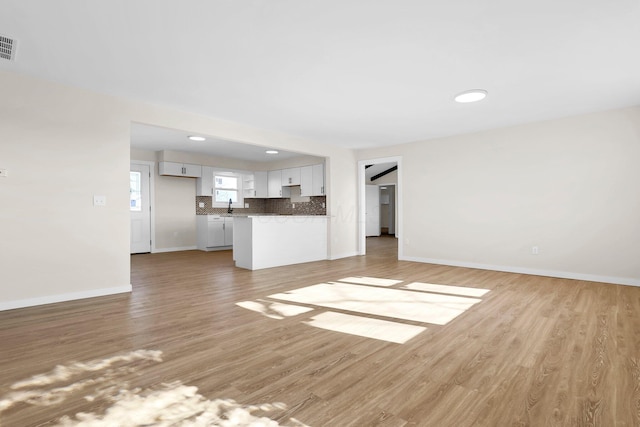 unfurnished living room with light hardwood / wood-style floors and sink