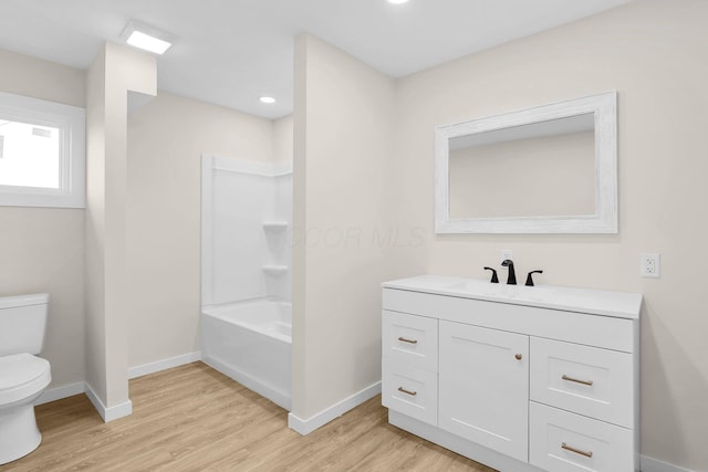 full bathroom with hardwood / wood-style floors, vanity, toilet, and shower / tub combination