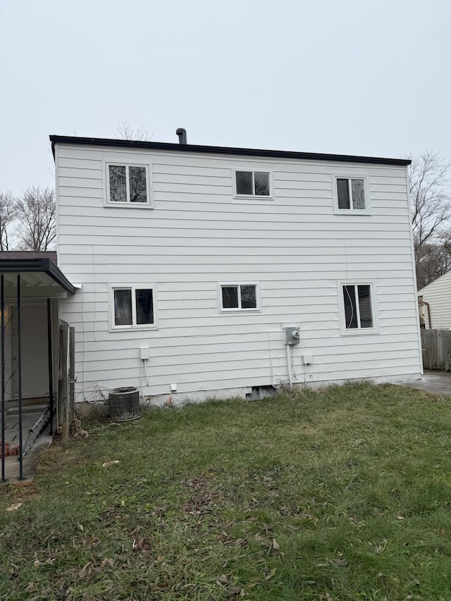 rear view of house featuring a yard and central air condition unit