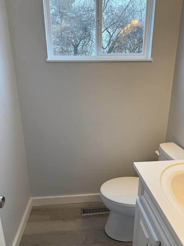 bathroom featuring hardwood / wood-style flooring, vanity, and toilet