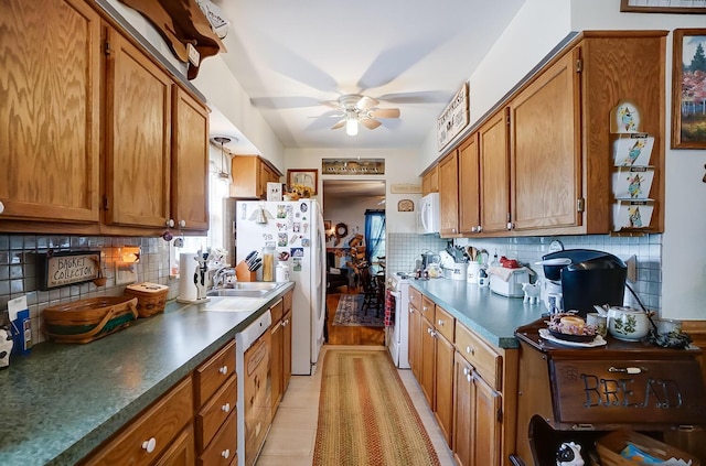 kitchen featuring decorative backsplash, white appliances, ceiling fan, and sink