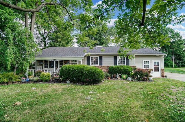 ranch-style house featuring covered porch and a front yard