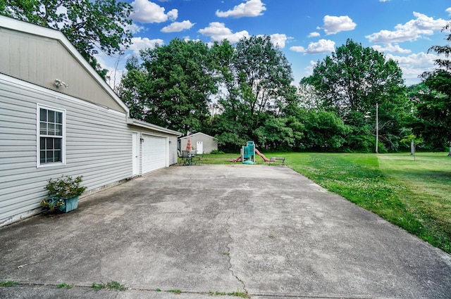 view of patio / terrace featuring a playground and a garage