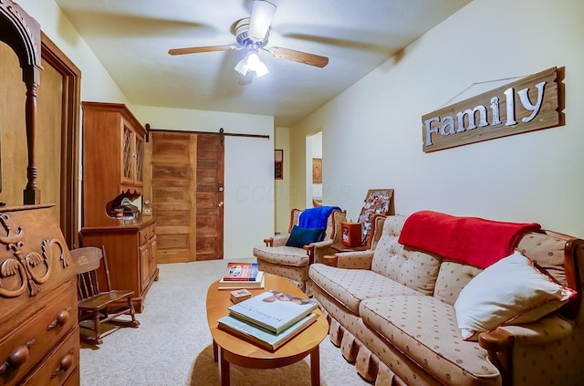 living room featuring a barn door, ceiling fan, and light colored carpet