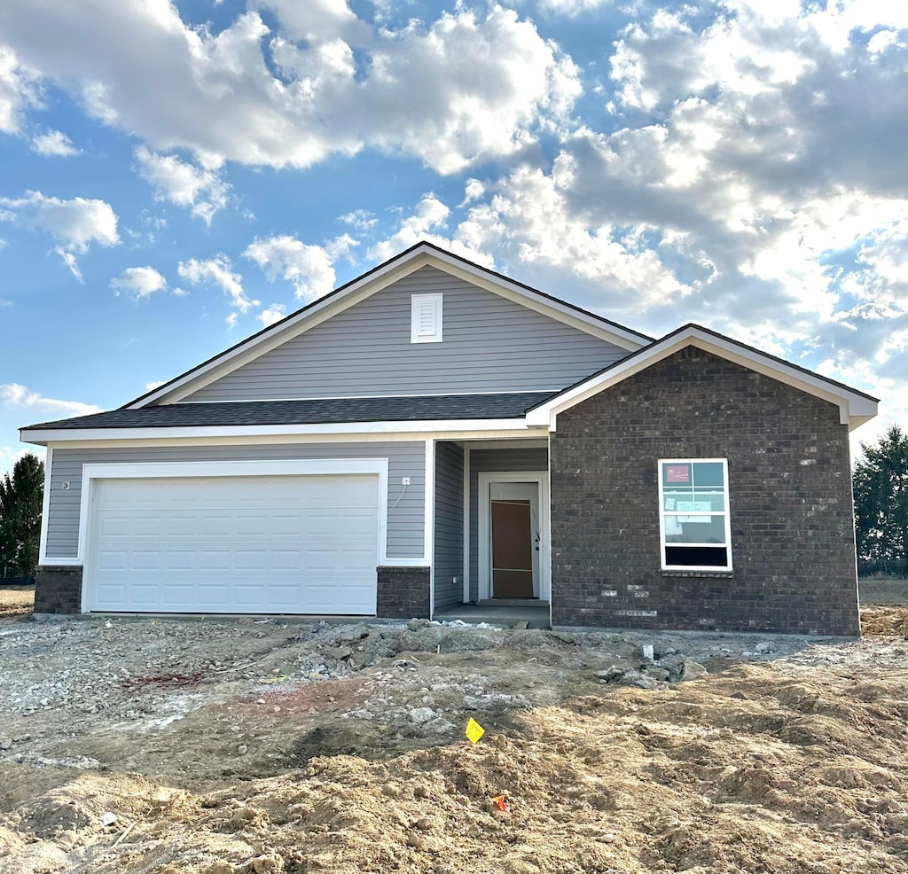 view of front of home with brick siding, driveway, and an attached garage