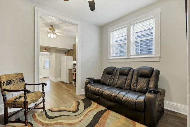 living room featuring ceiling fan and light hardwood / wood-style flooring