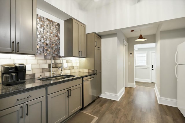 kitchen with dishwasher, sink, dark stone countertops, tasteful backsplash, and decorative light fixtures