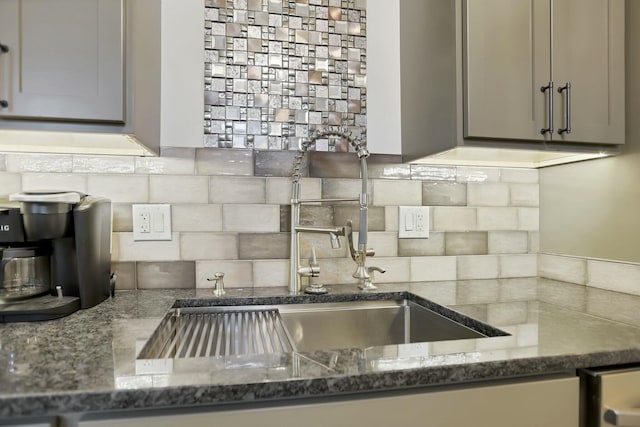 kitchen with gray cabinetry, backsplash, and dark stone counters