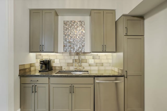 kitchen with gray cabinetry, sink, stainless steel dishwasher, decorative backsplash, and dark stone countertops