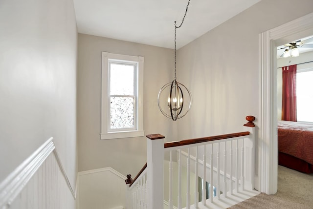 stairway featuring carpet flooring and an inviting chandelier