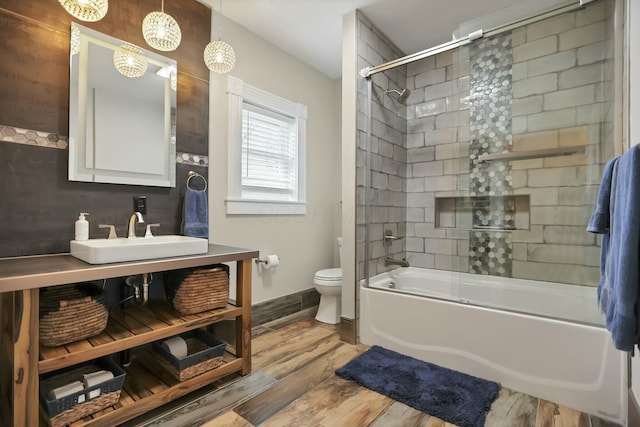 full bathroom with shower / bath combination with glass door, toilet, vanity, and hardwood / wood-style flooring