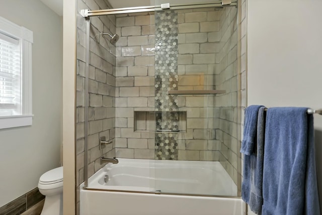 bathroom with shower / bath combination with glass door and toilet