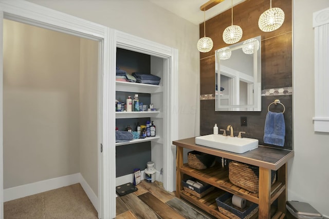 bathroom with hardwood / wood-style flooring, built in shelves, and vanity