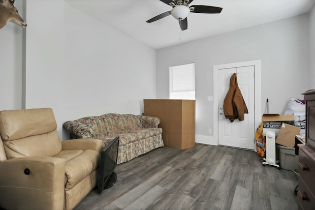 living area featuring ceiling fan and dark hardwood / wood-style flooring