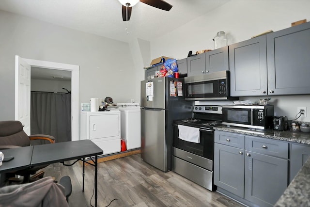 kitchen with gray cabinetry, dark hardwood / wood-style floors, separate washer and dryer, and appliances with stainless steel finishes