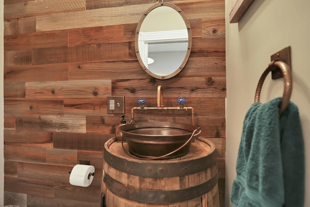 bathroom with wood walls and sink