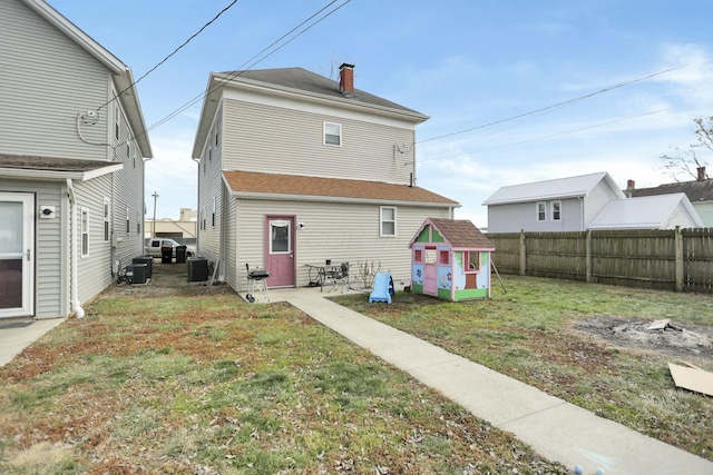 rear view of house with a lawn, central AC, and a patio area