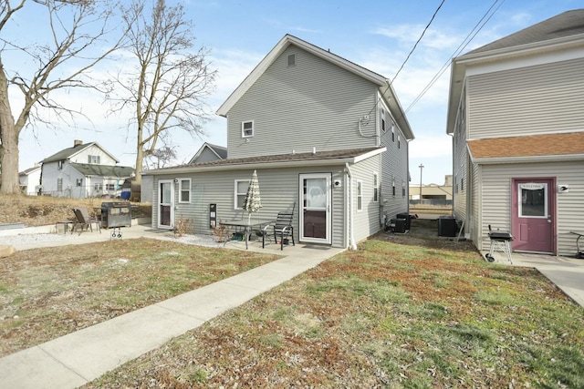 back of property with central AC, a yard, and a patio