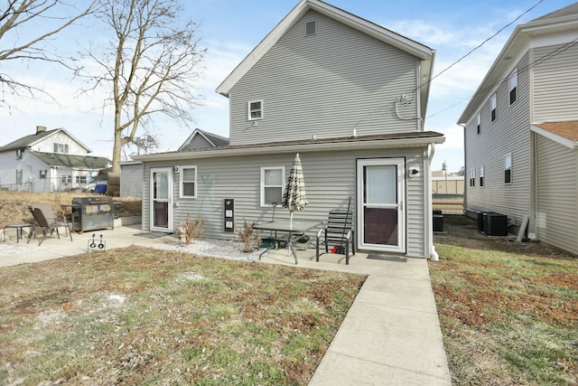 rear view of house featuring a patio area, a yard, and central AC