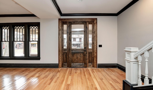 foyer with wood-type flooring and crown molding