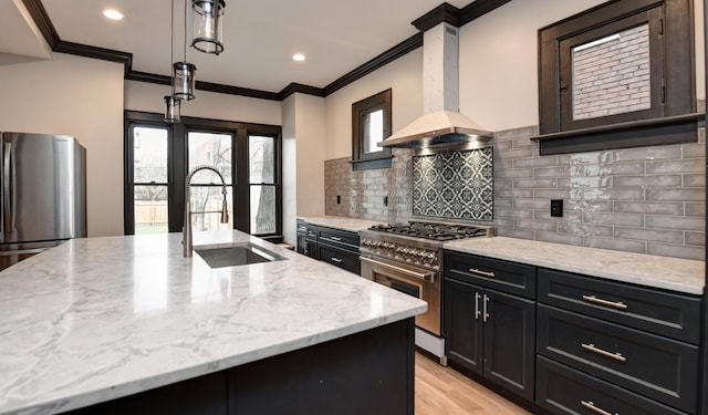 kitchen featuring stainless steel appliances, light stone counters, sink, and extractor fan