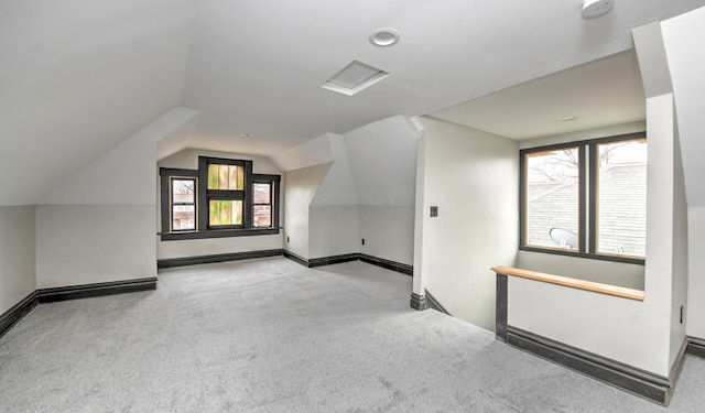 bonus room featuring light carpet and vaulted ceiling