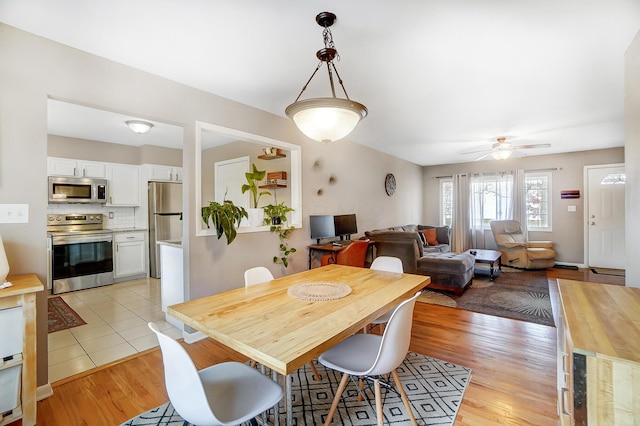 dining room with ceiling fan and light wood-type flooring