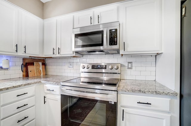 kitchen with tasteful backsplash, light stone countertops, appliances with stainless steel finishes, and white cabinets