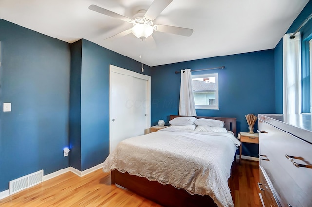 bedroom featuring hardwood / wood-style flooring, ceiling fan, and a closet