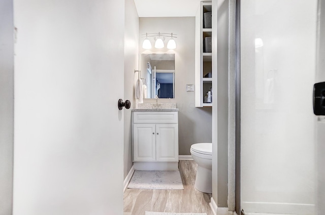 bathroom with vanity, wood-type flooring, and toilet