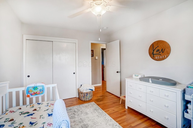 bedroom with light hardwood / wood-style floors, a closet, and ceiling fan