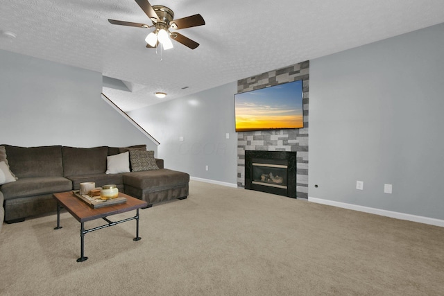 carpeted living room featuring ceiling fan, a fireplace, and a textured ceiling