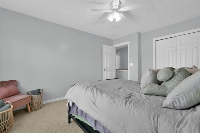 carpeted bedroom with a textured ceiling, a closet, and ceiling fan