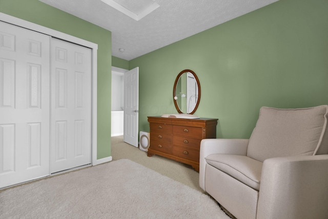 living area featuring light colored carpet and a textured ceiling