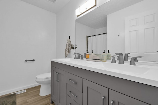 bathroom featuring a shower with shower curtain, vanity, hardwood / wood-style flooring, and toilet